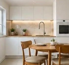 Clean modern apartment kitchen with white cabinets and a wooden dining table